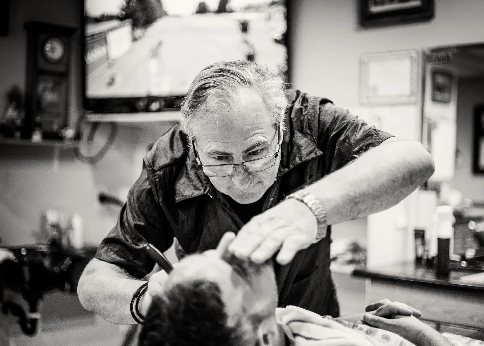 Ferenc Geber giving a precision haircut at Rooster’s Barbershop
